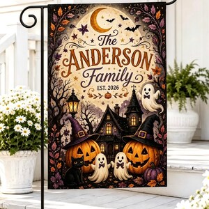 Puede incluir: Una bandera de jardín rectangular con una escena de Halloween que muestra una casa embrujada, dos calabazas con sombreros de bruja, un gato negro y dos fantasmas. El texto dice The ANDERSON Family EST. 2026 bajo una luna creciente y murciélagos.