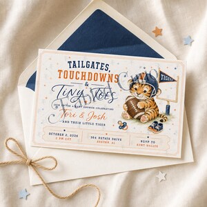 Puede incluir: Una tarjeta de invitación rectangular para baby shower con un tigre en acuarela que lleva un casco de fútbol americano y sostiene un balón. El texto dice Tailgates, Touchdowns & Tiny Toes, Tori & Josh y su pequeño tigre, con detalles.