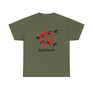 Peut inclure: Un t-shirt à manches courtes vert olive avec un motif noir représentant un vol d'oiseaux. Un cercle rouge avec une ligne diagonale est superposé sur les oiseaux. Le mot DeFlock est imprimé en noir sous le motif graphique.