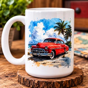 May include: A white ceramic mug featuring a watercolour-style illustration of a vintage red car parked on a sandy beach. The scene includes tall palm trees, a bright blue sky with white clouds, and a glimpse of the ocean in the background.