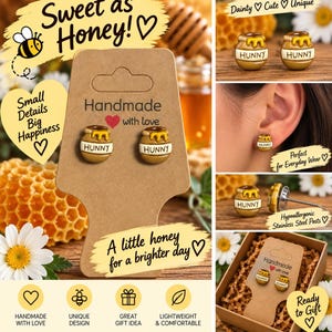 May include: A pair of stud earrings shaped like small brown honey pots with yellow honey dripping from the top. Each pot features the word HUNNY printed in black letters. The earrings are attached to a brown cardboard display card with the text Handmade with love.