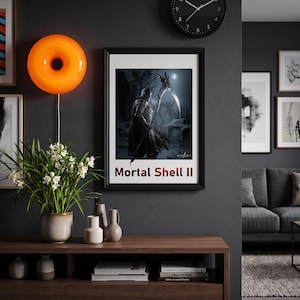 May include: A framed rectangular wall art print titled Mortal Shell II, featuring a dark fantasy character holding a large scythe in a moonlit forest. The print is displayed on a dark gray wall next to a bright orange circular wall lamp.