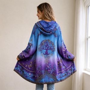 Könnte beinhalten: Eine Kapuzenjacke mit einem Farbverlauf von Hellblau oben bis Dunkelviolett unten. Auf der Rückseite befindet sich eine auffällige Baumgrafik mit komplexen Ästen und floralen Mustern, die sich über den gesamten Stoff erstrecken.