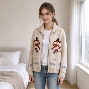 Peut inclure: Un gilet zippé en tricot couleur crème doté d'un col châle et de deux poches avant. Le pull présente un motif intarsia répétitif de têtes de renard dans des tons marron, noir et blanc, agrémenté de petites empreintes de pattes bleues sur l'ourlet.