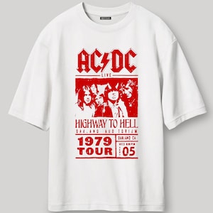 Puede incluir: Una camiseta blanca de corte oversize con un estampado gráfico rojo de la banda AC/DC, el texto Highway to Hell, 1979 Tour y detalles del concierto en Oakland, CA. La prenda incluye el texto Oversized Fit y Premium Heavy Gauge Fabric.