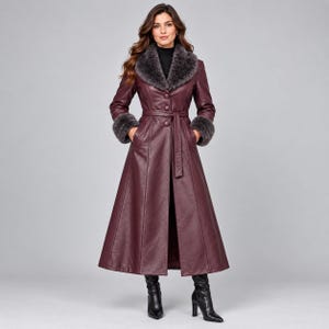 May include: A long, deep burgundy coat featuring a dark gray faux fur collar and matching faux fur cuffs. The coat has a button-front closure, a belted waist, and a flared skirt silhouette. It is paired with black heeled boots.
