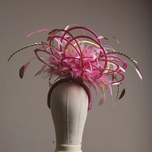 以下が含まれることがあります： 黒い持ち手と「But first, coffee」の手書き風の文字が入った白いセラミックマグ。マグカップは白い表面に置かれています。マグカップはおそらく温かい飲み物用です。