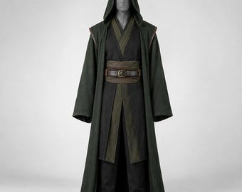 May include: A dark green hooded robe worn over a black tunic and trousers. The outfit includes a wide, dark brown fabric sash cinched at the waist with a brown leather belt featuring a metal buckle. The ensemble is displayed on a mannequin.