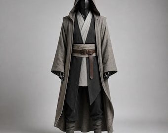May include: A hooded robe ensemble featuring a long, textured taupe outer cloak layered over a charcoal grey tunic and matching trousers. The outfit includes a light grey inner vest and a wide, dark brown leather belt with a metal buckle at the waist.