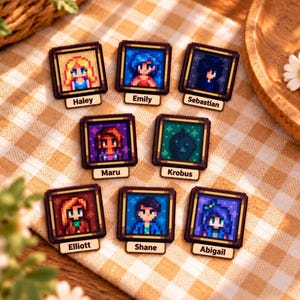 May include: Eight square wooden pins featuring pixel art character portraits from Stardew Valley. Each pin displays a unique character with a name tag below, including Haley, Emily, Sebastian, Maru, Krobus, Elliott, Shane, and Abigail.