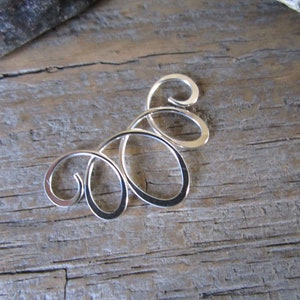 May include: Silver swirl design earring, a delicate and intricate piece of jewelry.