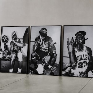 May include: Three framed black and white photographic prints featuring basketball players. The left print shows a player with a trophy, the center print shows a player in a jacket, and the right print shows a player in a Bulls jersey with a cigar.
