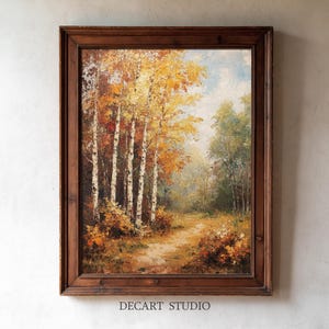 Può includere: Un dipinto a olio in una cornice di legno marrone scuro raffigurante un sentiero boschivo fiancheggiato da betulle con fogliame autunnale giallo e arancione. La scena presenta pennellate materiche, un cielo azzurro e il testo DECART STUDIO in basso.