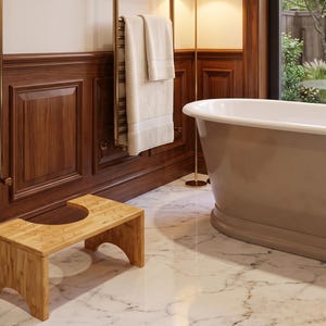 May include: A rectangular bamboo bathroom stool with a U-shaped cutout on the top surface. The stool features a natural light wood grain finish, four sturdy legs with arched cutouts, and a low-profile design for use in a bathroom setting.