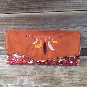Cartera grande de mujer en ante color caoba con bordado de flechas atrapasueños y tejido lie de vie con flores silvestres, 12 tarjeteros