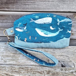Trousse à maquillage femme, pochette clutch en  faux cuir bleu, tissu bleu avec des baleines et fond marin, dragonne amovible, porte-cartes