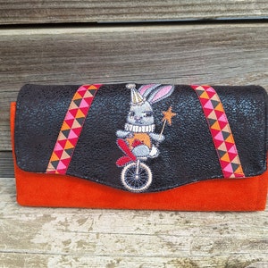Grand portefeuille femme brodé en  faux cuir noir et suédine orange avec broderie lapin de cirque, tissu motif géométrique,  12 porte-cartes