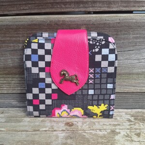 Mini portefeuille femme en tissu en tissu noir avec des motifs géométriques et  patte de fermeture en  cuir fuchsia, 4 porte-cartes