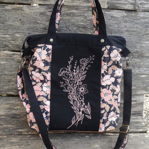 Sac à bandoulière  pour femme en toile et tissu noir avec des fleurs roses et blanche et liège marron, broderie  fleurs sauvages, tote bag