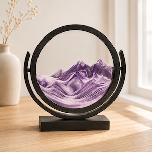 Purple 3D flowing sand art displaying mountain landscape, round glass sand picture for shelf decor.