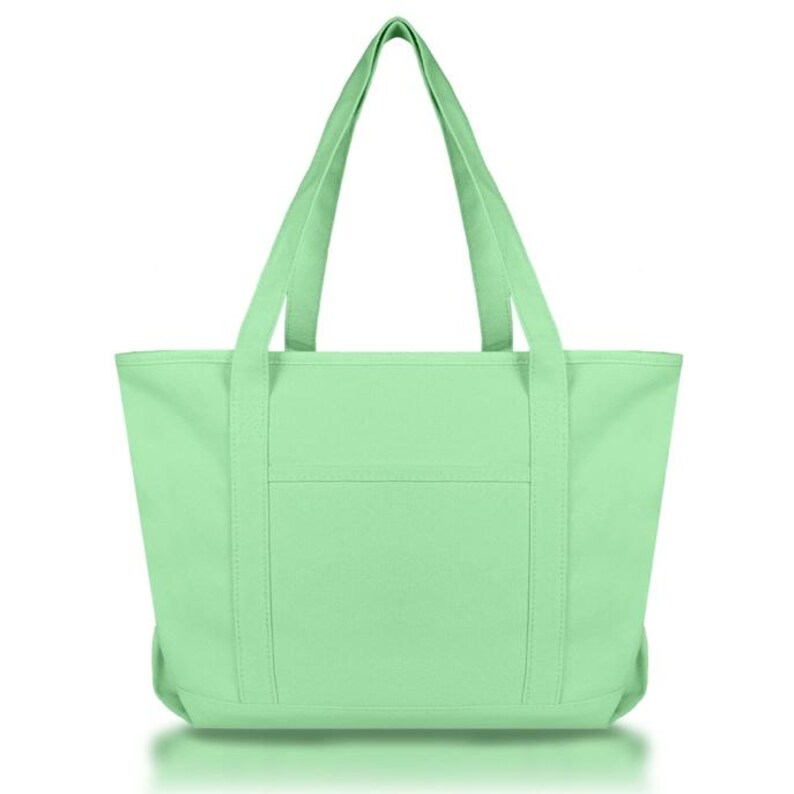 May include: A solid light mint green tote bag featuring two long shoulder straps, a rectangular main compartment, and a single horizontal exterior pocket centered on the front panel. The bag is constructed with reinforced vertical stitching.