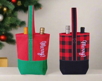 May include: Two red and black wine bottle gift bags with a green and black bottom. Both bags have a black strap handle and say "Merry!" in white lettering.