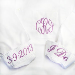 May include: White dress shirt with purple embroidered details. Features a monogram on the pocket and the date "3.9.2013" on one cuff. The other cuff reads "I Do" in purple script. A classic wedding or special occasion garment.