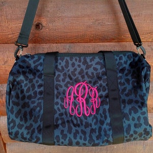 Black animal print duffel bag with hot pink monogram