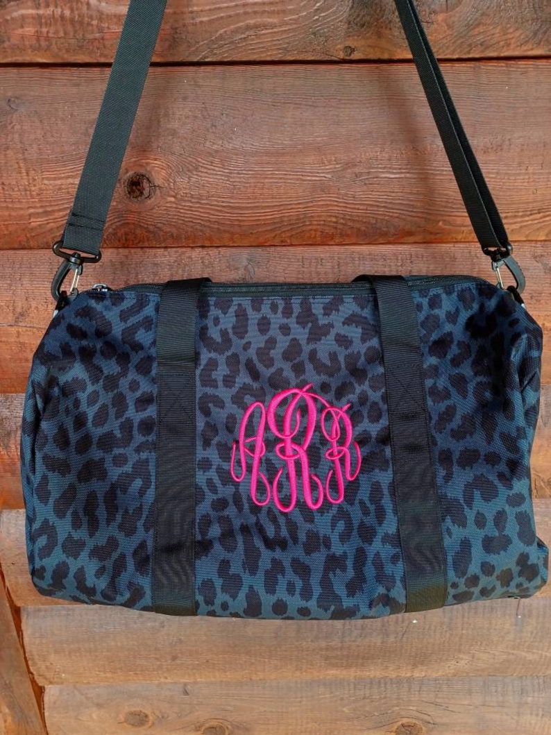 Black animal print duffel bag with hot pink monogram
