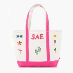 May include: White canvas tote bag with pink accents, featuring embroidered summer-themed icons like sunglasses, a starfish, a flamingo, and a sun. The bag has the letters "SAE" embroidered on the front, along with flip-flops, a wine glass, and a palm tree.