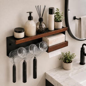 May include: A wall-mounted bathroom shelf featuring a black metal frame with dark wood accents. The shelf holds a soap dispenser, a reed diffuser, a bottle, a small potted plant, and a tissue box with a paper towel dispenser underneath.
