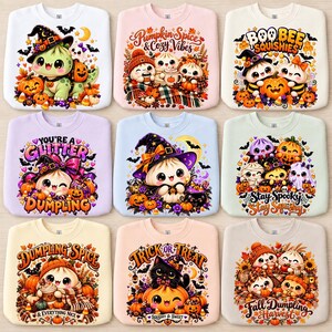 Könnte beinhalten: Eine Kollektion von neun Rundhals-Sweatshirts mit verschiedenen farbenfrohen Halloween-Illustrationen von Teigtaschen, Kürbissen, Geistern und Katzen. Jedes Shirt zeigt einzigartige saisonale Schriftzüge wie Pumpkin Spice, Boo Bee Squishies, You're a Glitter Dumpling, Stay Spooky Stay Squishy, Dumpling Spice, Trick or Treat und Fall Dumpling Harvest.