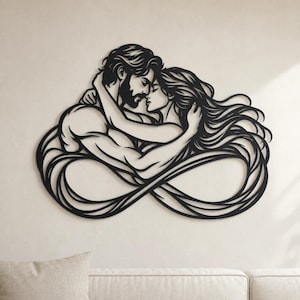 Könnte beinhalten: Ein Wandkunstobjekt aus schwarzem Metall, das die stilisierte Silhouette zweier sich umarmender Figuren zeigt. Das Design besteht aus fließenden Linien, die ein Unendlichkeitssymbol bilden, wobei sich das lange Haar und die Arme der Figuren verflechten.