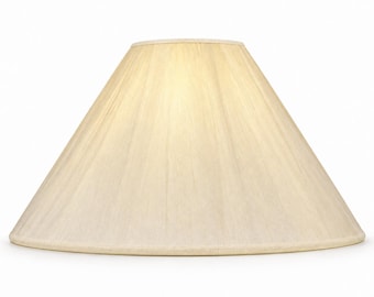 Pode incluir: Um abajur cônico com um exterior de tecido na cor creme, apresentando uma textura plissada vertical sutil. O abajur possui uma base circular larga e uma abertura superior mais estreita, com um acabamento de borda a condizer.