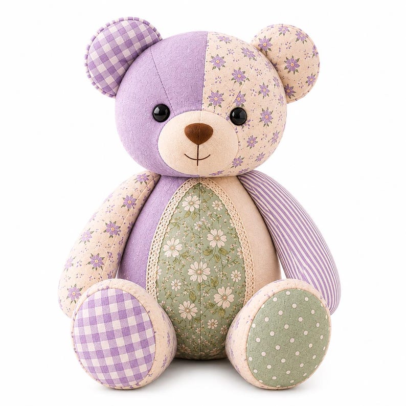 May include: A plush teddy bear constructed from various fabric patches in shades of purple, green, and cream. The bear features a mix of gingham, floral, and striped patterns, with black button eyes, a brown stitched nose, and lace trim details.