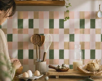 Könnte beinhalten: Ein Küchenrückwand-Design mit einem sich wiederholenden Gittermuster aus rechteckigen Fliesen in gedeckten Tönen von Salbeigrün, zartem Rosa, Creme und Beige. Die Fliesen wirken handbemalt mit subtilen Farb- und Texturvariationen an der Wand.