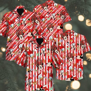 May include: A short-sleeved button-down shirt featuring a red and white diagonal striped pattern. The print includes various Disney characters wearing holiday accessories, such as Santa hats and reindeer antlers, interspersed with snowflakes.