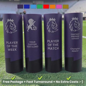 May include: Four cylindrical purple trophies with black bases, each featuring a white engraved lion logo and text. The trophies display the phrases Player of the Week, Your Custom Text+Logo, Player of the Match, and Fantasy Premier League Champion 2026/27.
