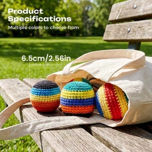 May include: Three round, crocheted yarn balls with horizontal stripes in black, blue, yellow, orange, and red. The balls measure 2.56 inches in diameter and are partially contained within a beige canvas tote bag.