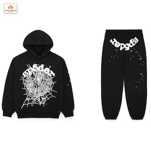 May include: A black hooded sweatshirt and matching sweatpants set. The hoodie features a large white spiderweb graphic with the text "sp5der" above it. The sweatpants display the text "sp5der" in white at the top with scattered white dots.