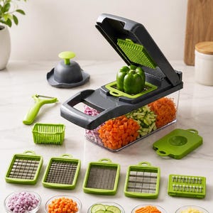 May include: A dark gray and lime green vegetable chopper with a clear collection container, featuring a hinged lid, multiple interchangeable stainless steel blade inserts, a green peeler, and a small circular hand-held food press tool.