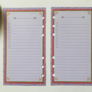 May include: Two rectangular planner inserts with light purple lined paper and a checklist column on the left. The border features a colorful pattern of small stars and circles. Each sheet has six circular punch holes along the side. A pink pen is included.