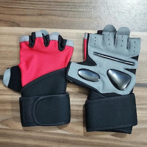 May include: A pair of fingerless athletic gloves featuring a bright red mesh back, black fabric accents, and a wide black wrist strap with a hook-and-loop closure. The palm side is light grey with black padded inserts and perforated ventilation holes.