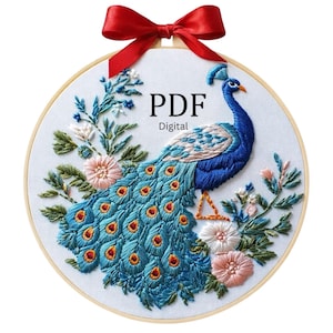 May include: A circular wooden embroidery hoop containing white fabric with a hand-stitched peacock design, featuring blue, teal, and pink floral accents. A bright red satin ribbon bow is attached to the top. The text PDF Digital is visible.