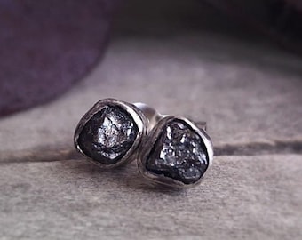 Peut inclure: Une paire de boucles d'oreilles en argent avec des pierres de diamant noir brut.