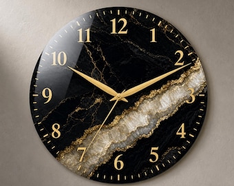 May include: A round wall clock featuring a black marble-like surface with a diagonal band of white and gold crystalline texture. The clock face displays gold-colored Arabic numerals from 1 to 12 and matching gold-colored hour, minute, and second hands.
