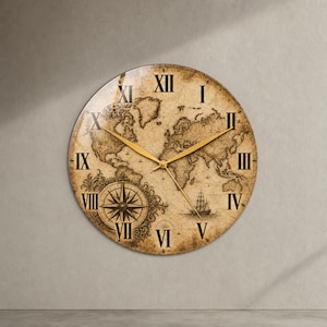 Peut inclure: Une horloge murale ronde présentant un fond de carte du monde de style ancien dans des tons sépia. Le cadran affiche des chiffres romains noirs de I à XII, une rose des vents détaillée en bas à gauche, un voilier et des aiguilles dorées.