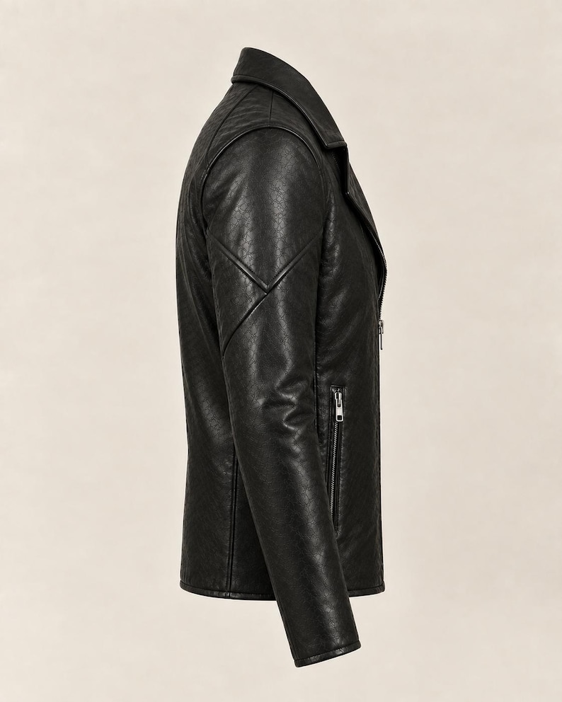 May include: A black jacket with a textured finish, featuring a notched collar, long sleeves with stitched panel detailing, and a vertical zippered pocket on the side. The garment is shown from a side profile view, highlighting the structured seams.