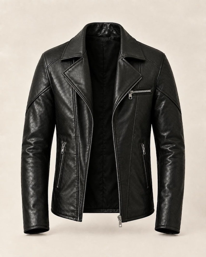 May include: A black leather jacket featuring a notched lapel, a diagonal front zipper closure, and three zippered pockets. The material displays a subtle, repeating embossed pattern across the surface, with silver-toned metal hardware throughout.