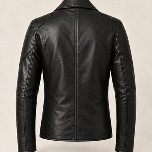 May include: A black jacket with a smooth, textured finish, featuring a structured collar, long sleeves with defined seam detailing along the shoulders and back, and a central vertical seam running down the back panel of the garment.